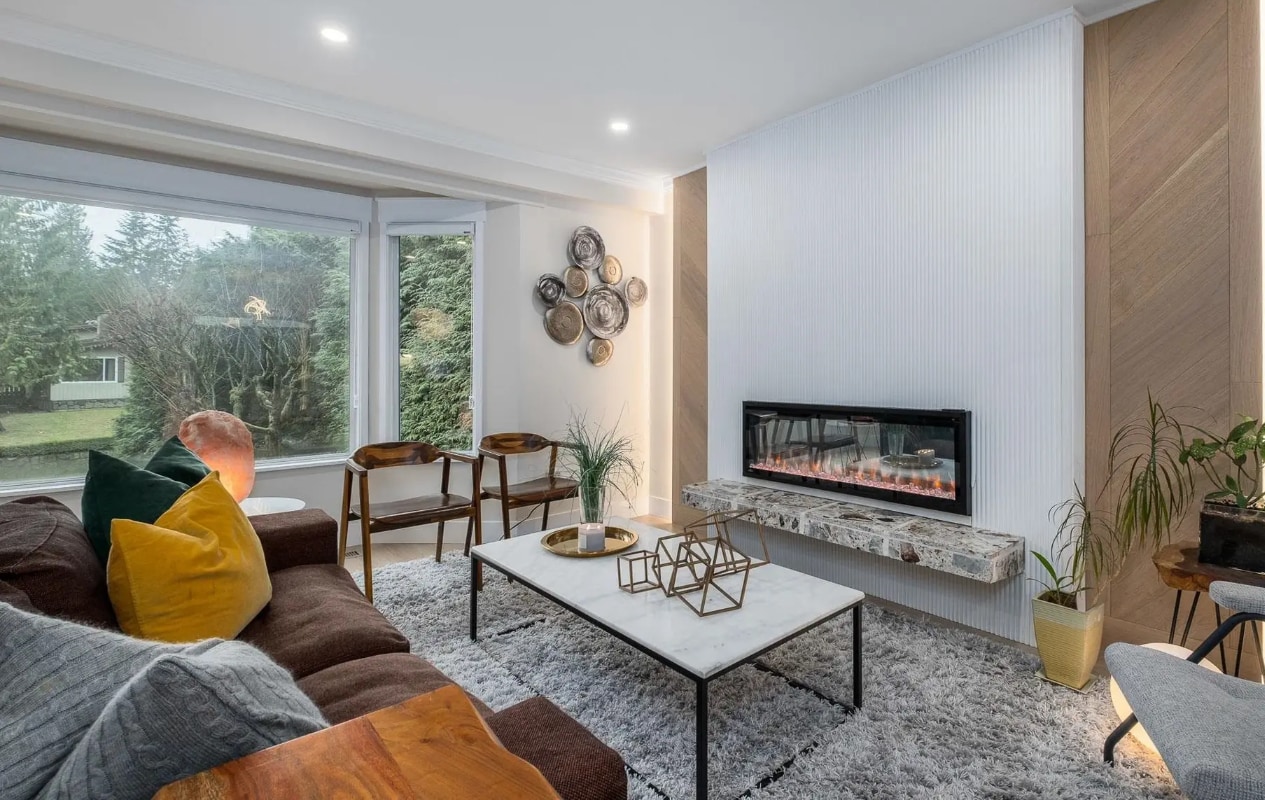 Modern living room after renovation with fluted panel accent wall, chevron wood pattern, and electric fireplace